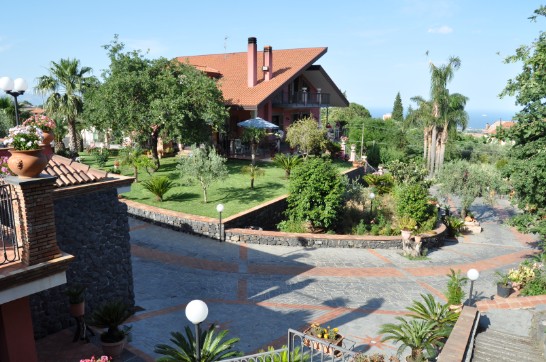 Césped en la parte de atrás de la casa de la villa de vacaciones de sol en Santa Venerina